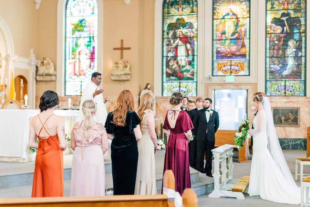 Bridal party surrounds the bride and groom as they face the pope during their catholic ceremony in Coeur d'Alene
