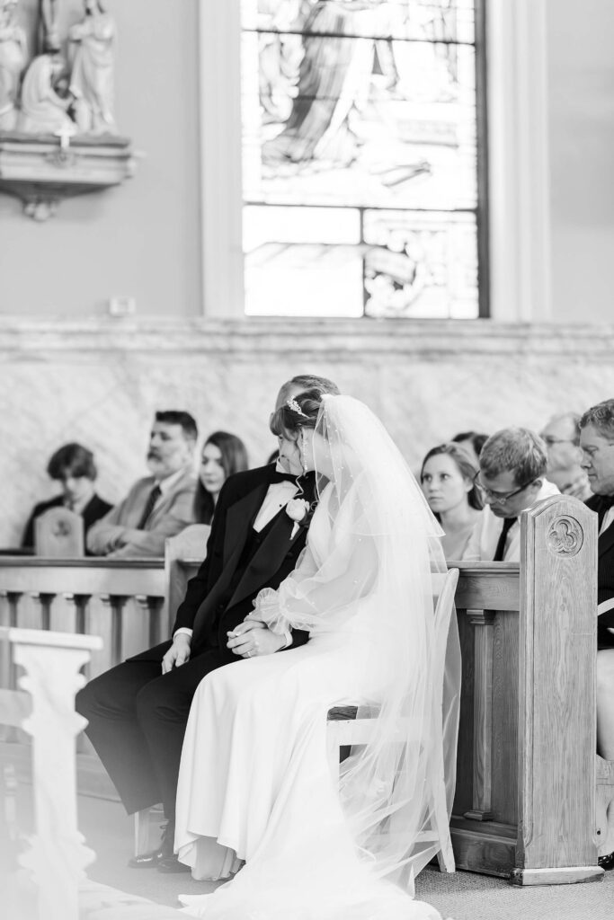 Groom whispers to bride during their Catholic ceremony at the Saint Thomas Church in Coeur d'Alene