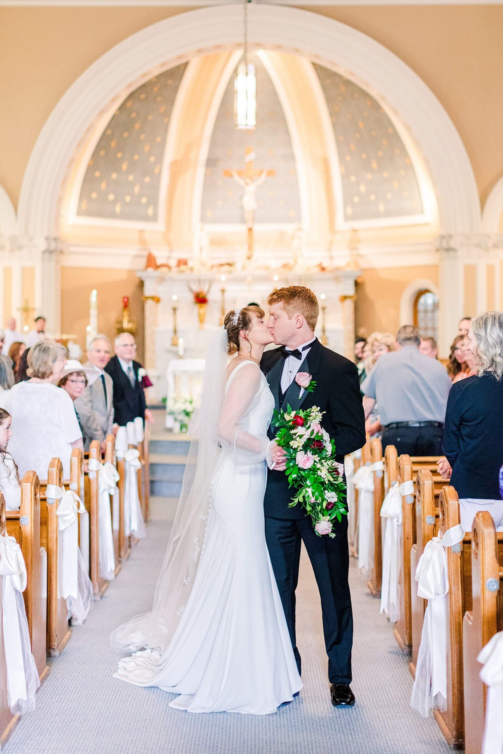 Couple Kiss as they walk back up the aisle of the Saint Thomas Church in Coeur d'Alene