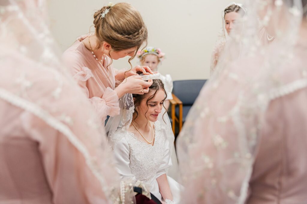 Bride Getting ready surrounded by her bridesmaids in blush