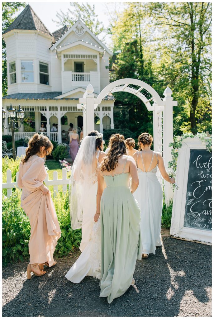 Bride with her Bridesmaids walking back into the Belle Gardens Wedding venue after taking their wedding photos 