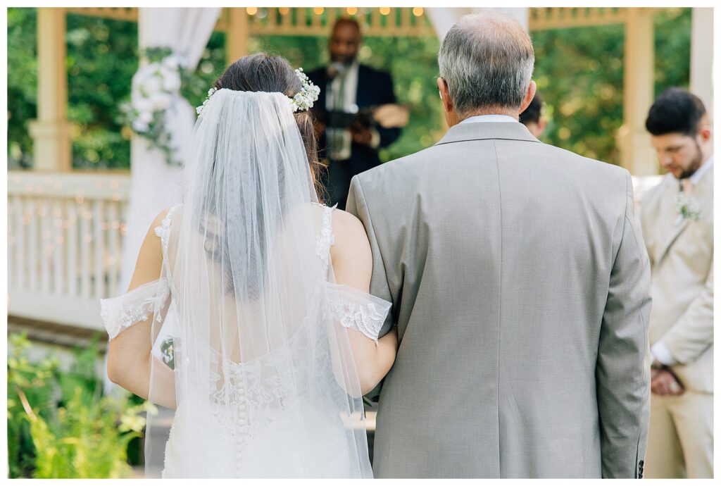 Bride holds her dads arm 